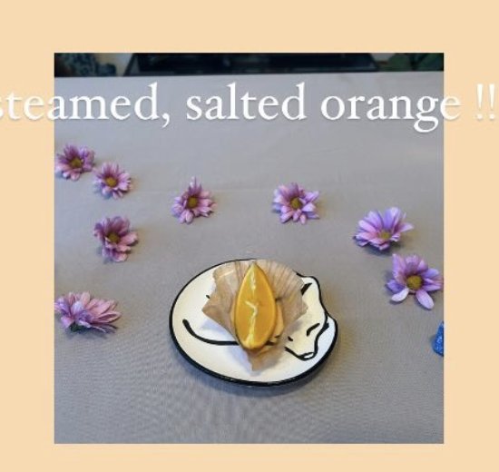 A steamed, salted orange slice served on a small illustrated plate.