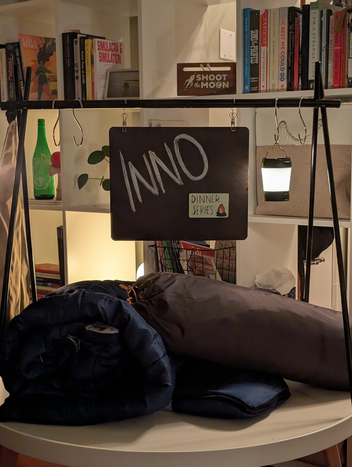 Campfire / PNW Summer dinner, an INNO Dinner Series sign next to camping gear.