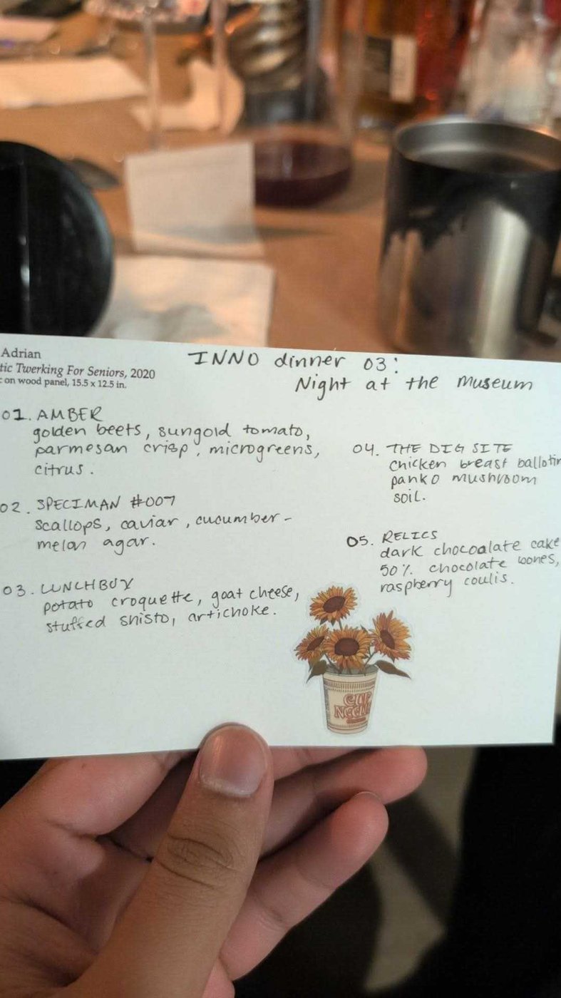 The full menu card, held up at the table: INNO dinner 03, Night at the Museum, with all five courses listed.